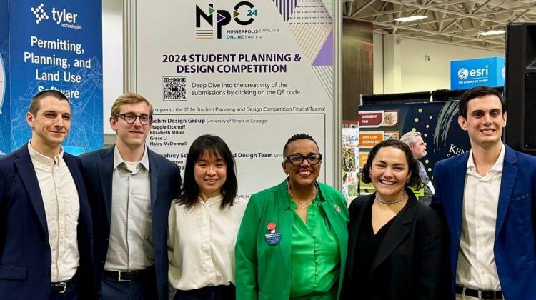 A group of people stand in front of a poster that reads: NPC 2024 Student Planning and Design Competition