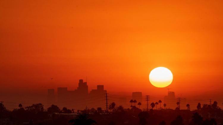 Yellow sun and orange sky over skyline