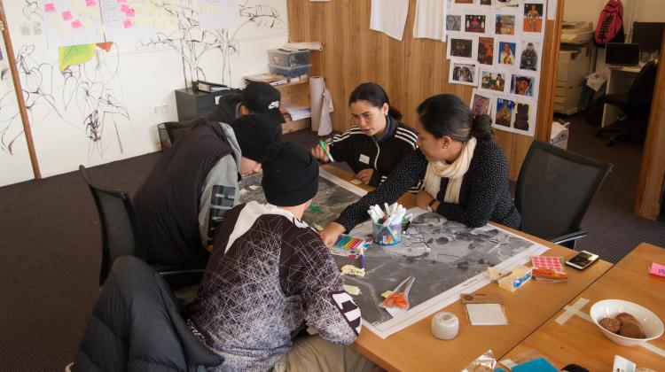 Participants gather around a table at a workshop in Kaikohe, Aotearoa New Zealand