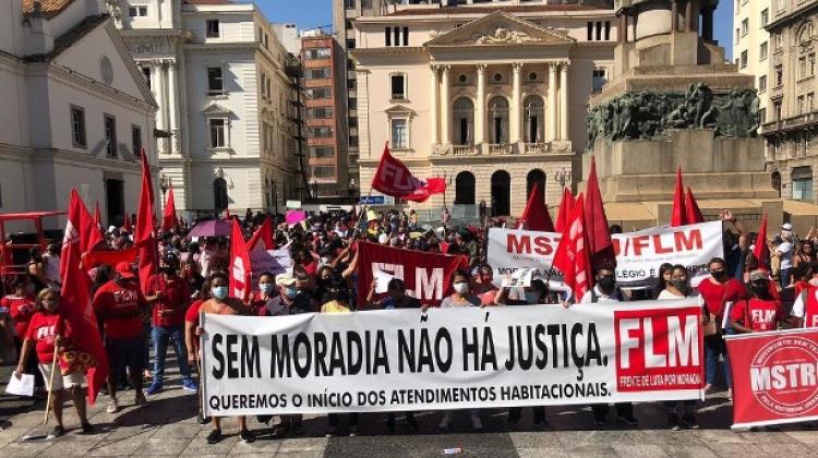 Sao Paulo, Brazil - protestors stand in a central square wearing read and carrying banners