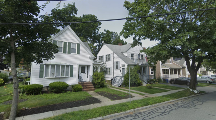 Three homes side by side on a leafy suburban street.