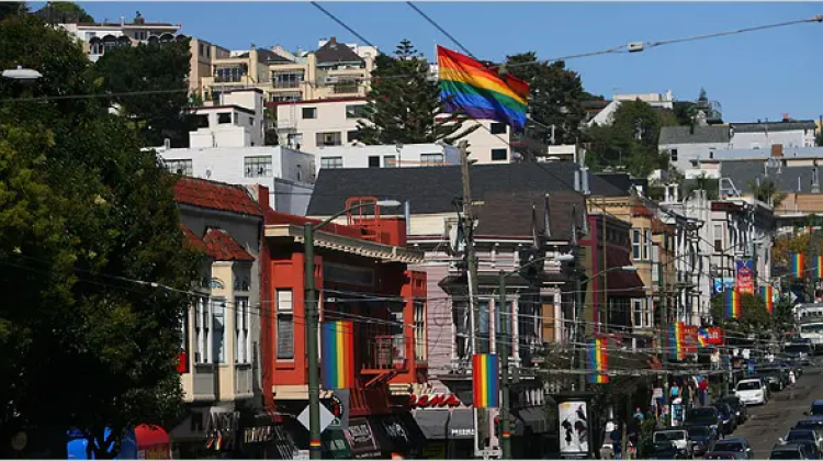 Image of city block in San Francisco with a rainbow flag centered in the photograph.